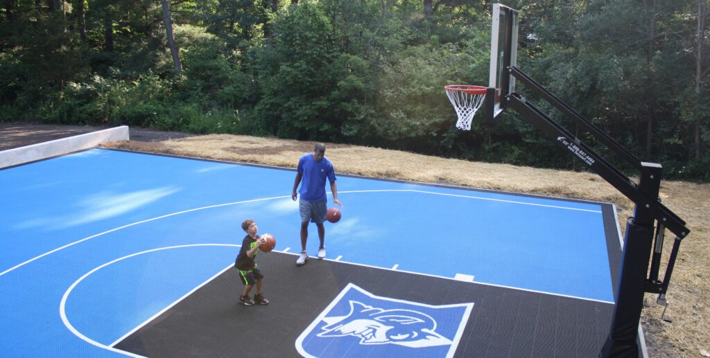One of FlexCourt's backyard courts with a child throwing a basketball