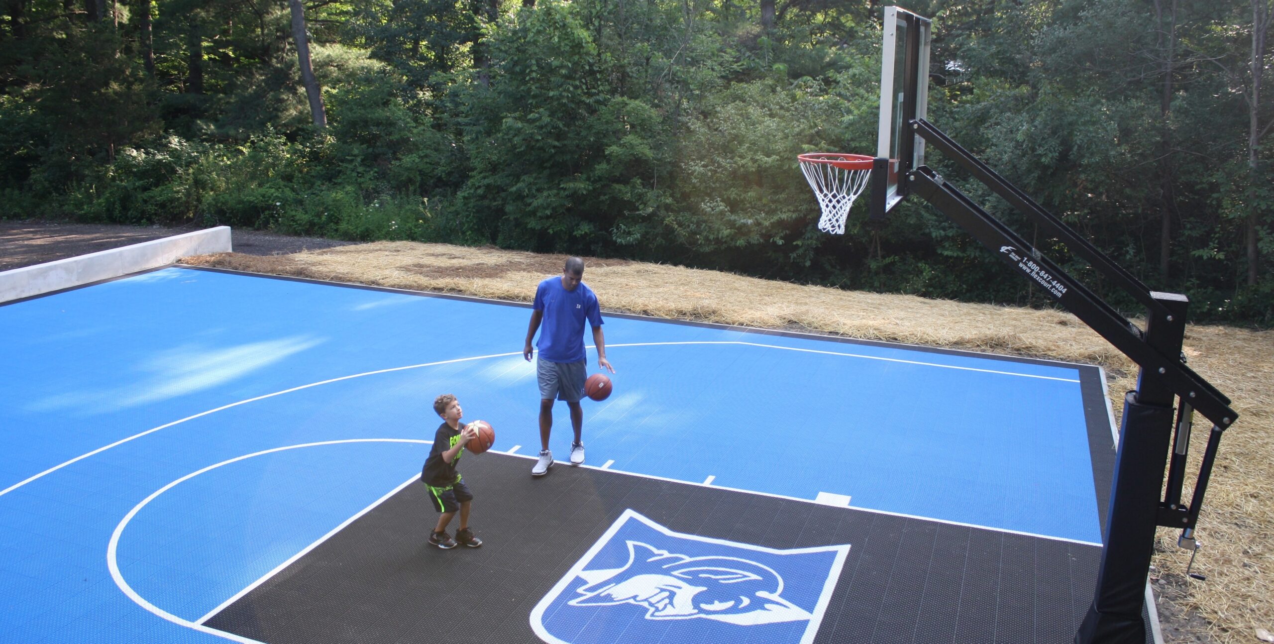 One of FlexCourt's backyard courts with a child throwing a basketball