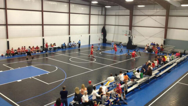 crowd watching a basketball game being played on a flexcourt court